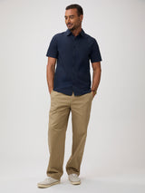 Man wearing a navy shirt and khaki  pants |  stretch fabric, side pleats, forgiving fit, all-day comfort