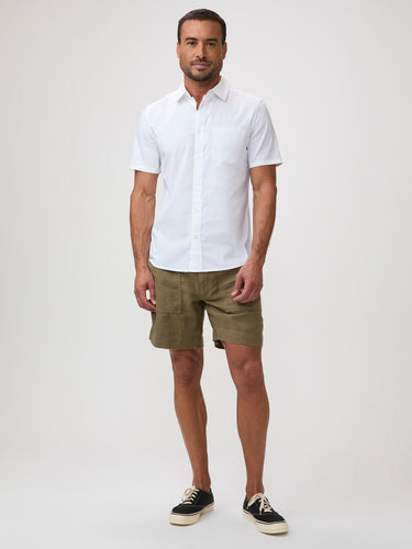 Man wearing a white short-sleeve shirt and green shorts | breathable button up shirts