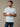 Man wearing light mint green/blue short-sleeve crewneck t-shirt and dark blue jeans, standing 