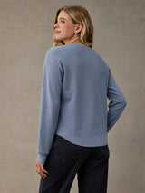 A woman shown from the back wearing a Skyline blue long-sleeve cozy thermal and dark jeans. Soft 280 GSM waffle knit fabric.