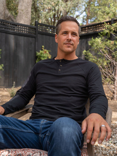 Ben is 6'1, 180lbs and wears a size M # Black Slim Fit Long Sleeve Henley Lifestyle Size Medium | Fresh Clean Threads