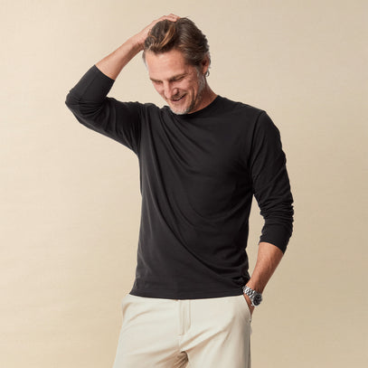 Man wearing a black long-sleeve shirt and khaki stretch tech pants | Fresh Clean Threads